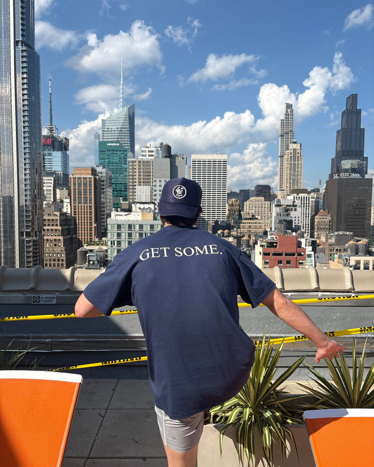 The Monday Tee in navy — GET SOME. back print worn against the New York skyline